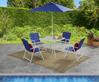 Blue fabric and white‑frame outdoor dining set with umbrella, shown on a stone patio beside a pool.